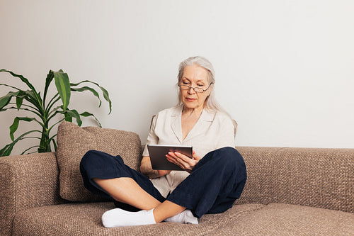 Woman in eyeglasses sitting on a sofa