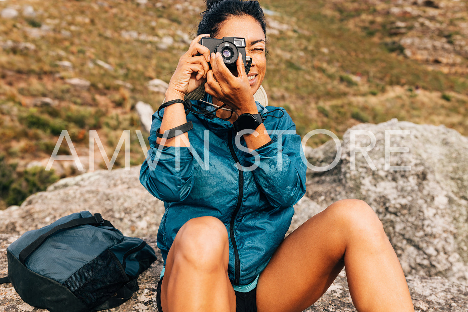 Woman hiker filming scenery while taking a break on a hill durin