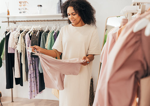 Young female buying clothes in local boutique