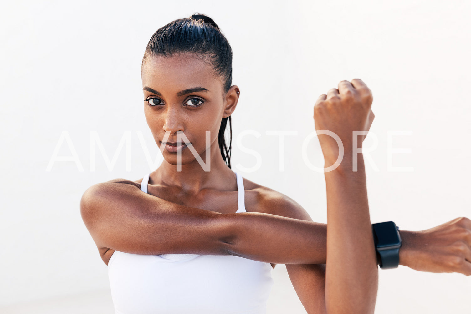 Portrait of a professional athlete warming up her hands. Fitness influencer flexing her hands and looking at camera.