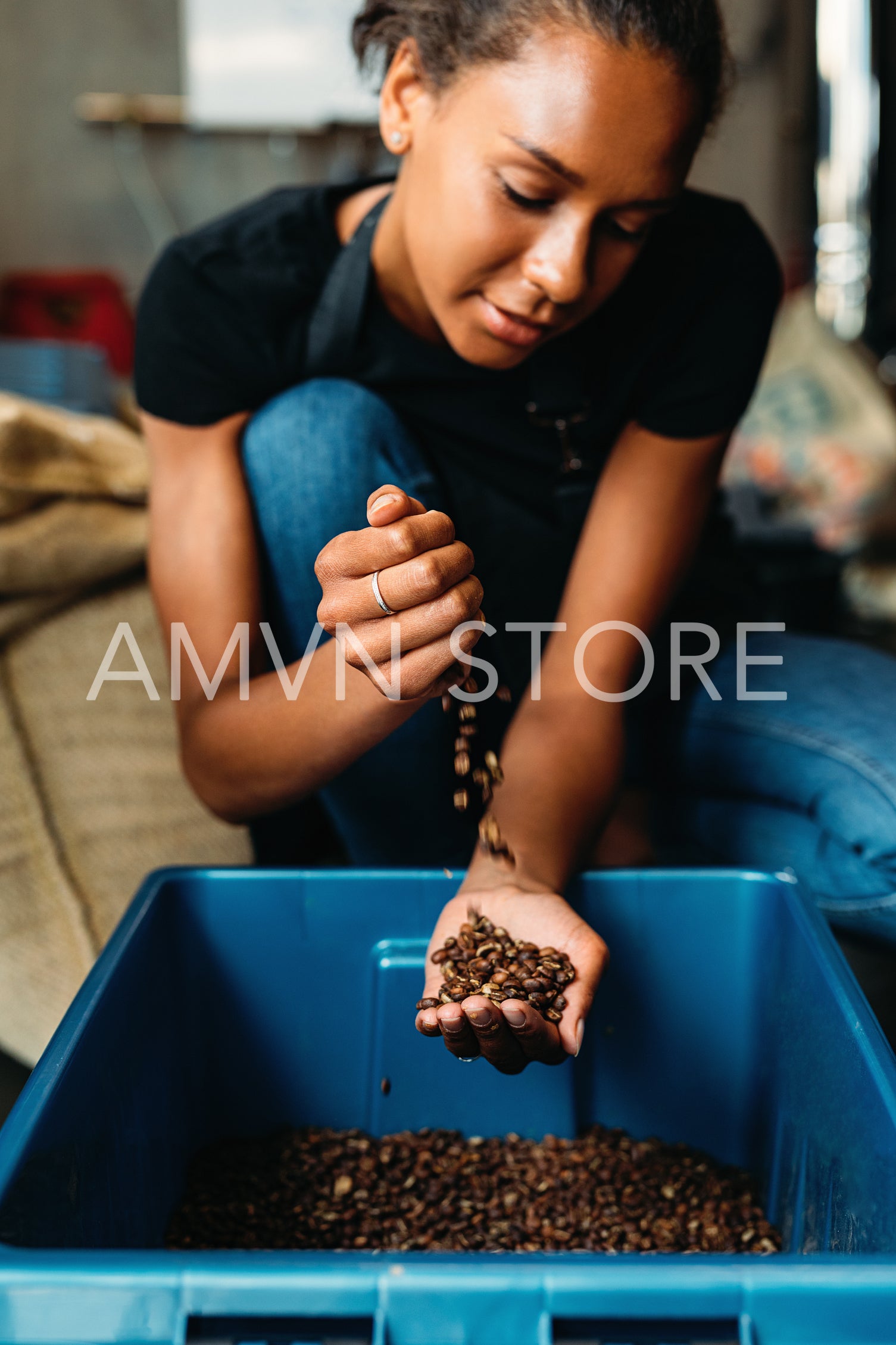 Smiling woman holding coffee beans in her hands	