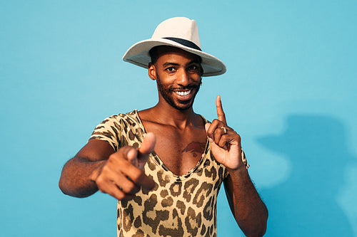 Young cheerful man dancing in studio and looking at camera