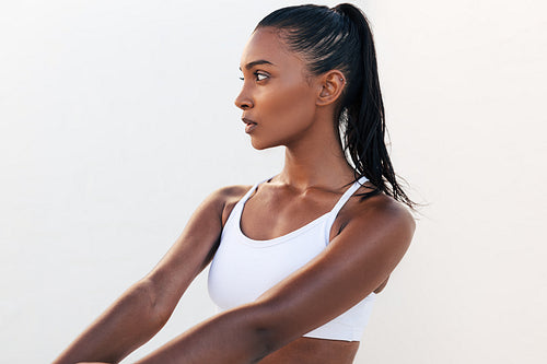 Slim woman looking away relaxing during training in outdoor gym. Young female relaxing wearing white fitness attire.