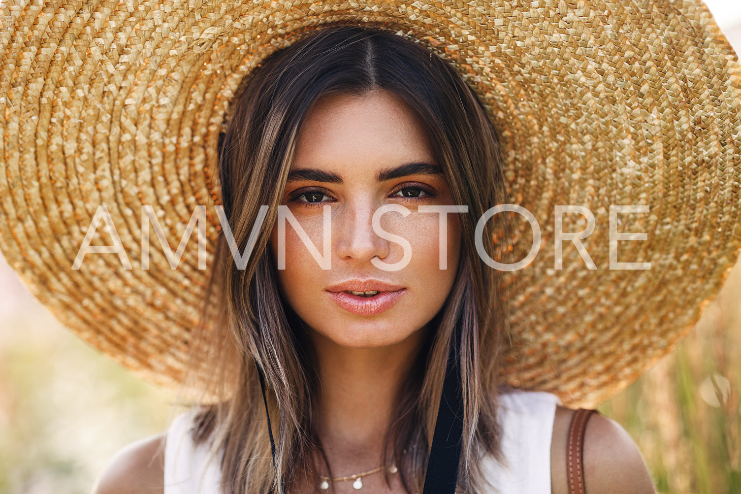 Close up portrait of a beautiful woman in straw hat looking at camera	