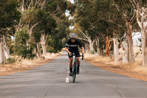 Sportswoman riding a bicycle in the center of an empty road. Pro