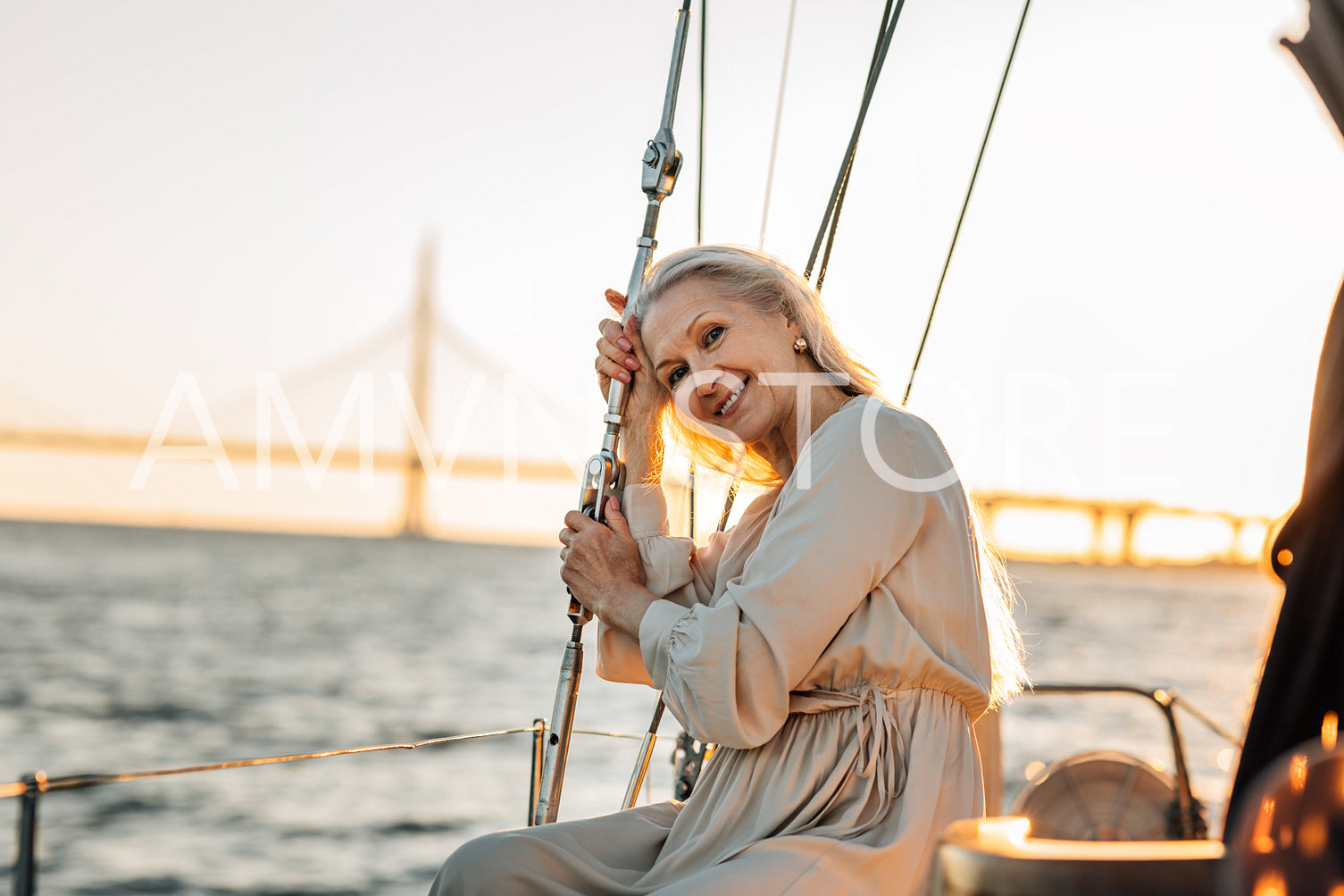 Elegant mature woman sitting on a yacht deck and looking a camera	