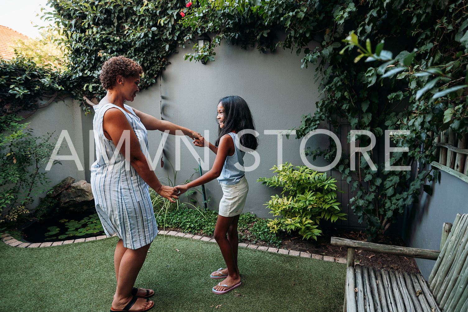 Granny and granddaughter dancing together at backyard