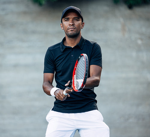 Portrait of a young tennis player in cap during a match