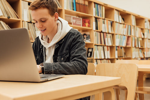 Smiling student preparing for exams in college library