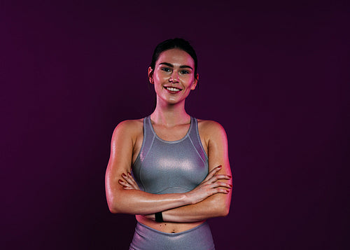 Portrait of a smiling confident sportswoman in silver fitness wear