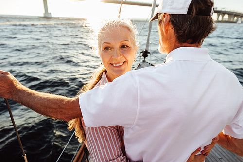 Portrait of a smiling mature woman hugging her husband and looking away