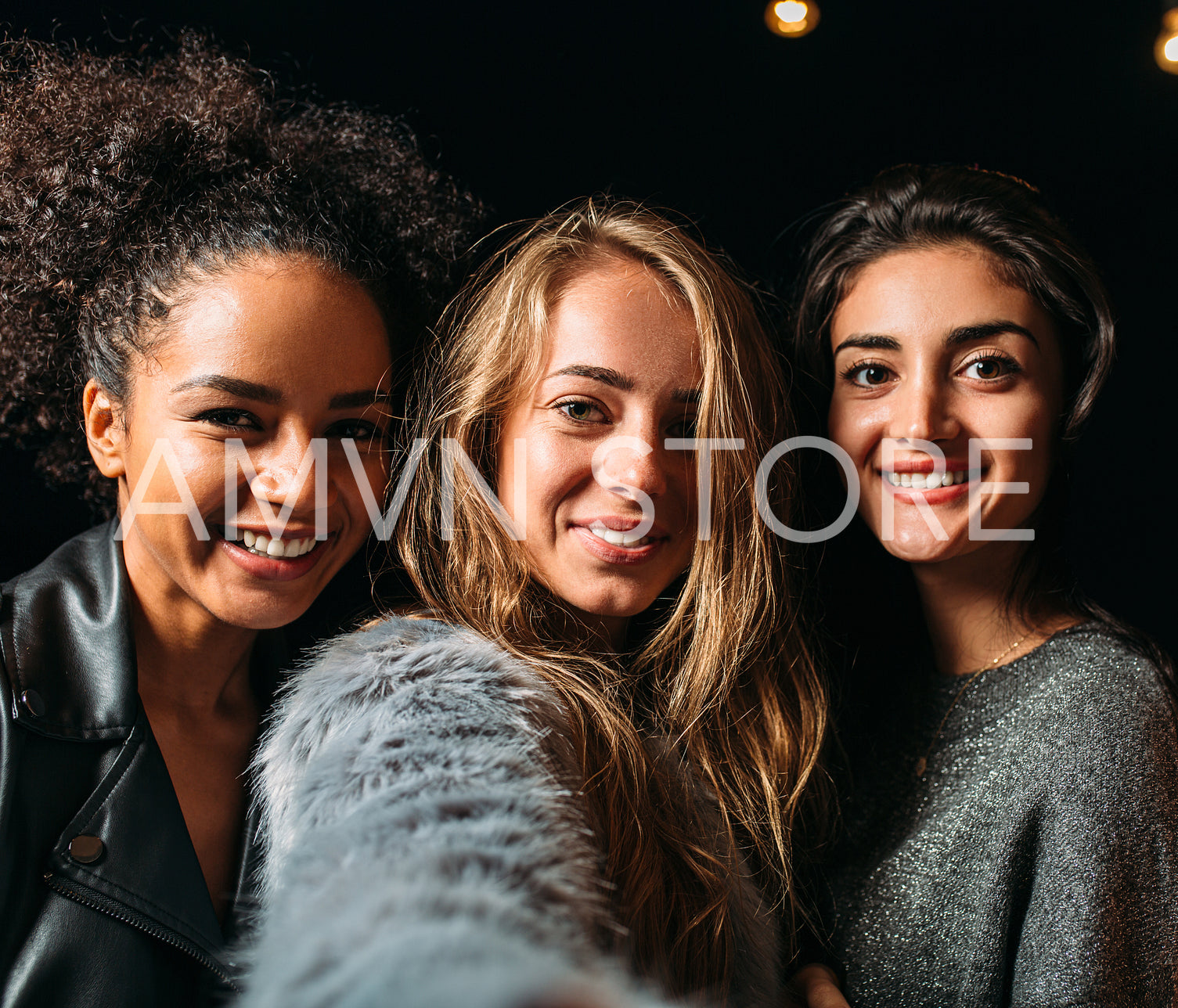 Three beautiful women taking selfie at night 