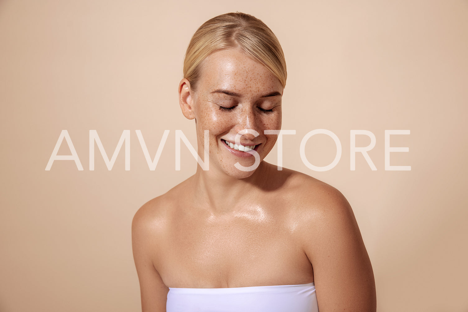 Cheerful woman with freckles posing in studio against pastel bac