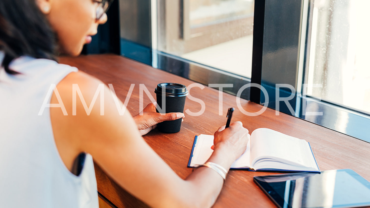 Young entrepreneur taking notes in cafe	