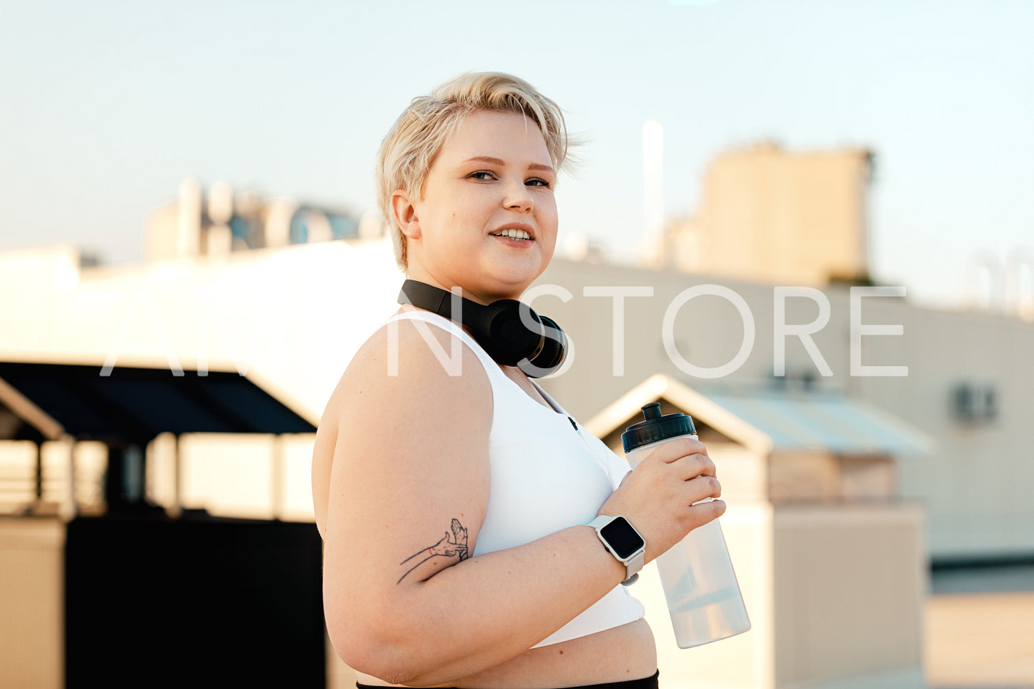 Portrait of a young curvy woman holding a bottle taking a break