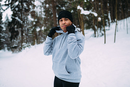 Young sportsman relaxing after training in snowy park