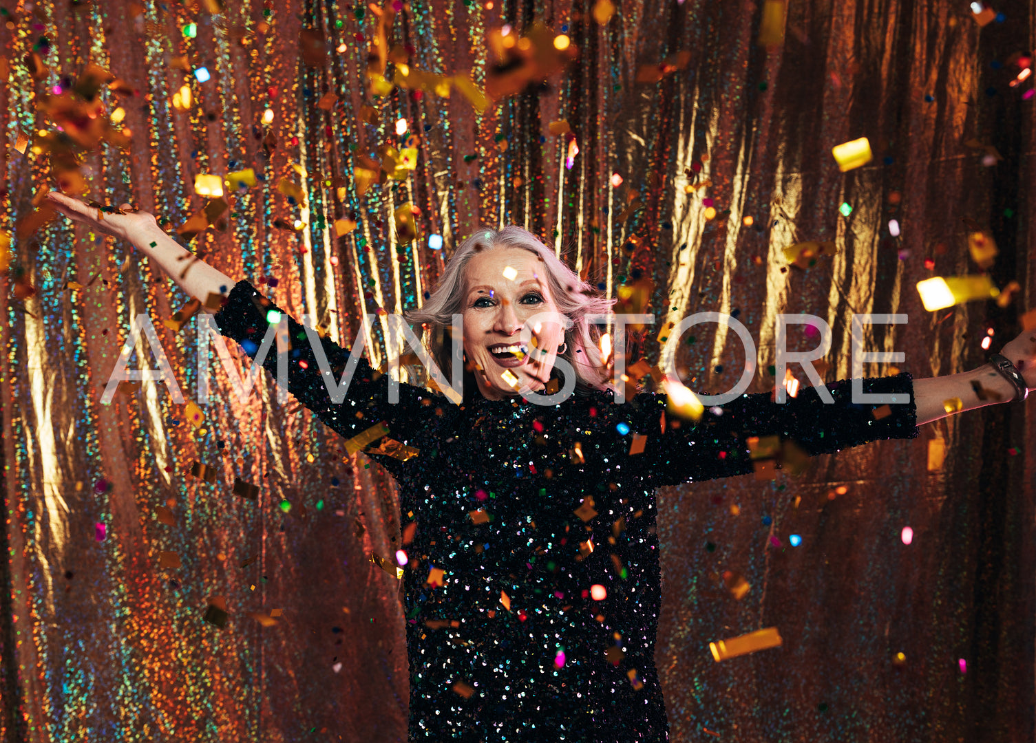 Smiling senior woman in black dress having fun under colorful co