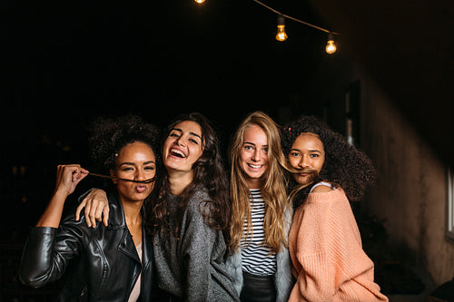 Shot of female friends having fun at night, looking at camera