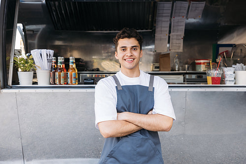 Portrait of a confident entrepreneur. Food truck owner wearing apron standing with crossed arms.