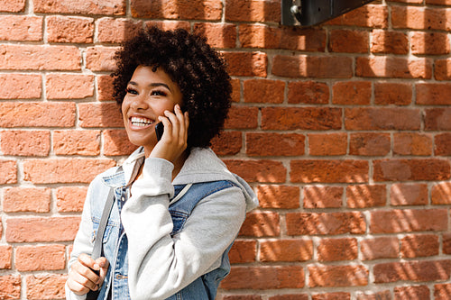 Portrait of a beautiful smiling woman talking on cell phone outdoors