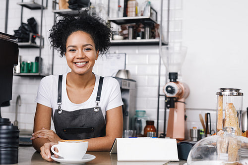 Portrait of a young curly waitress in a cafeteria