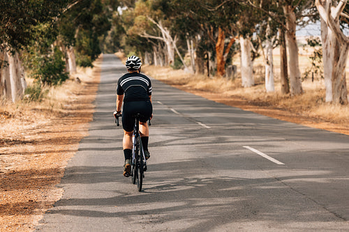 Rear view of professional female cyclist riding bicycle on count