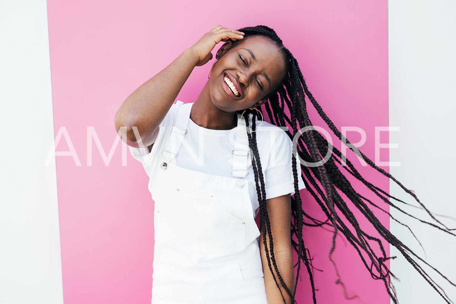 Portrait of a positive smiling woman in casuals having fun while standing at pink wall