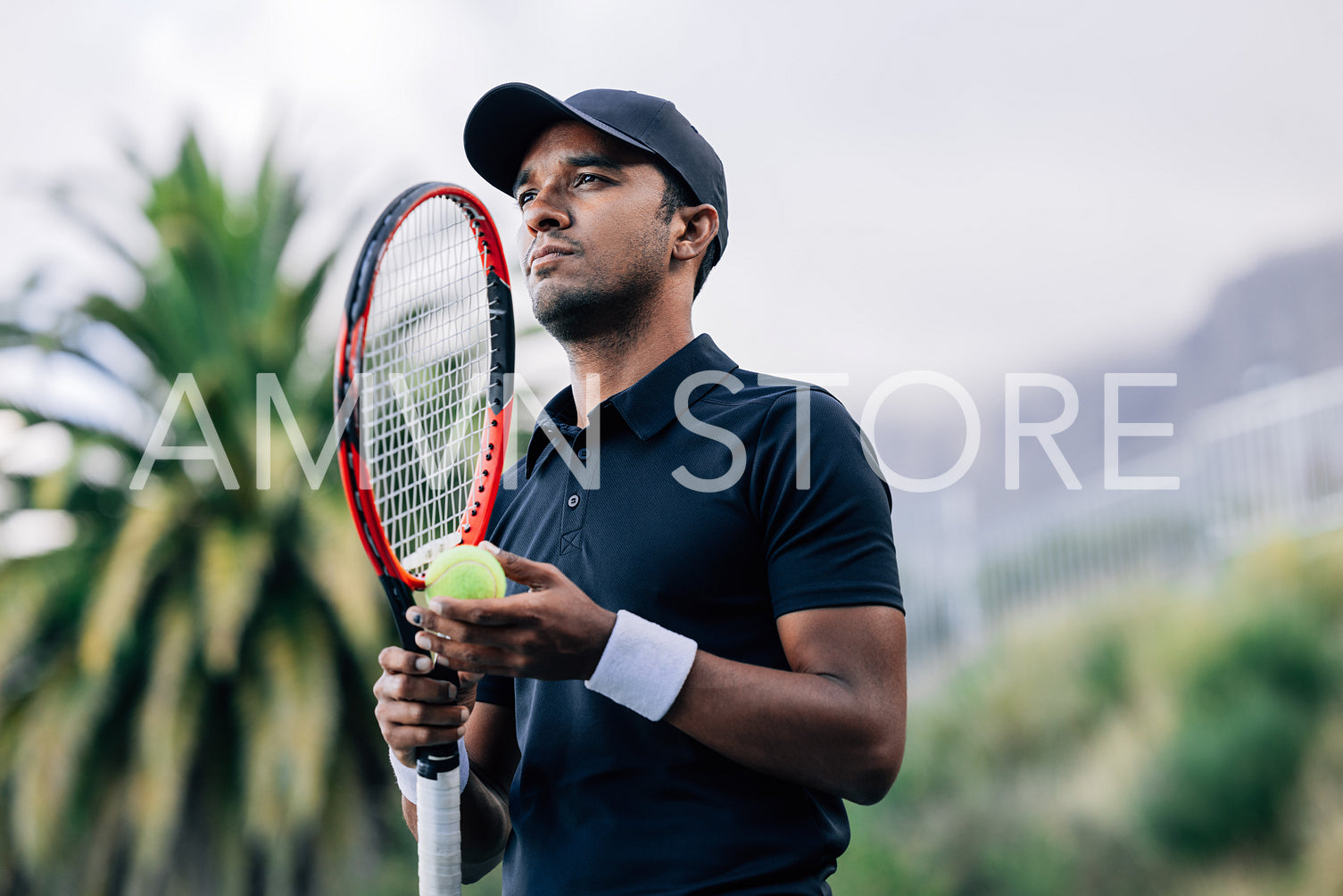 Young tennis player with racket standing outdoors