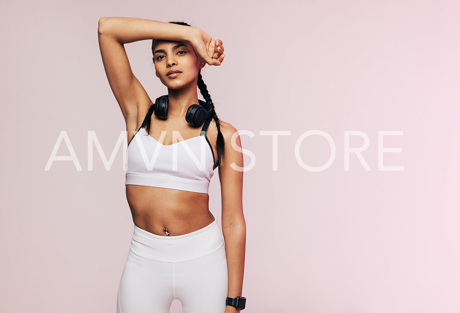 Tired woman in sportswear wearing headphones looking at camera in studio