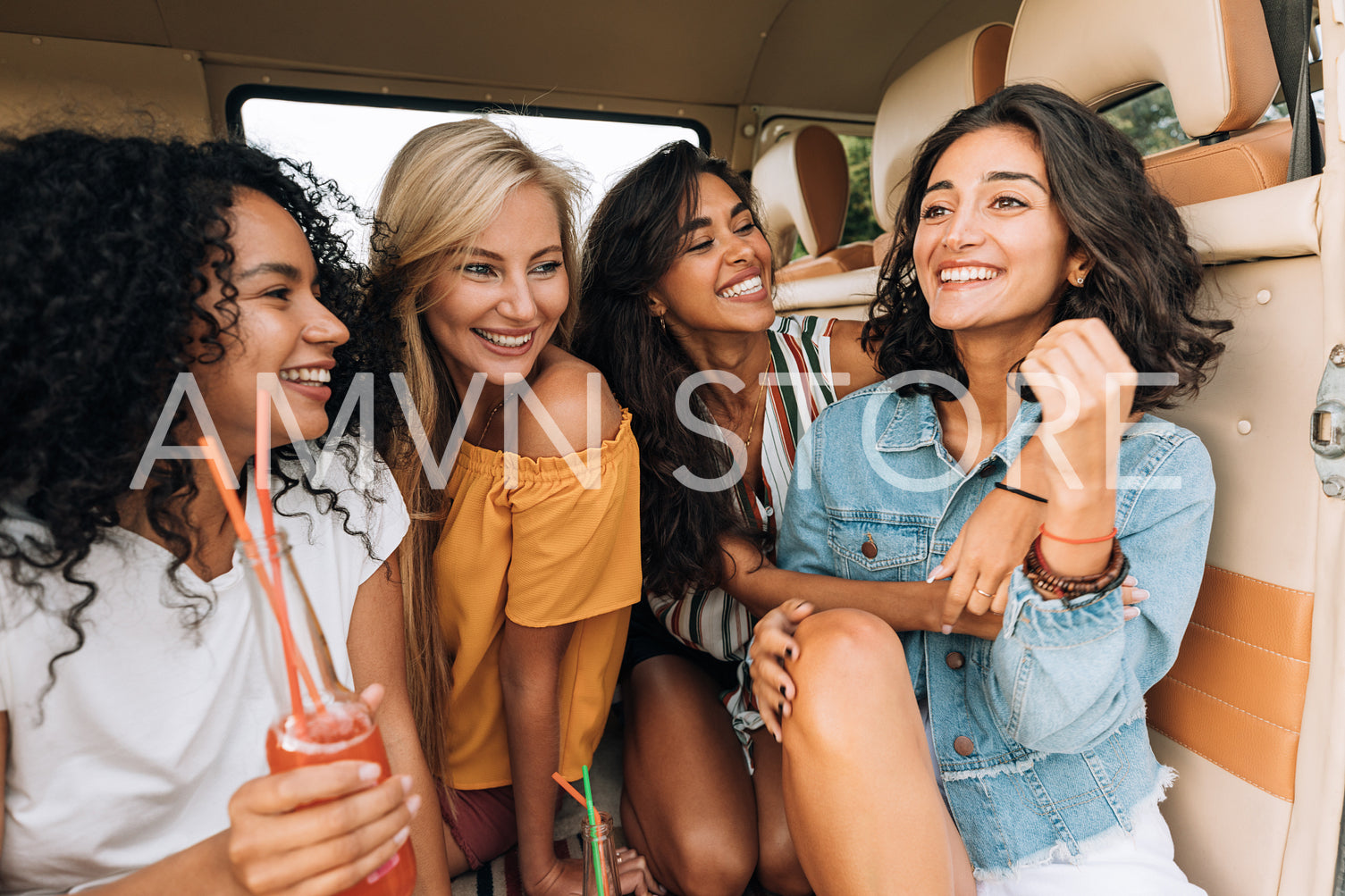 Smiling females sitting together in van enjoying summer vacation. Beautiful women on road trip.