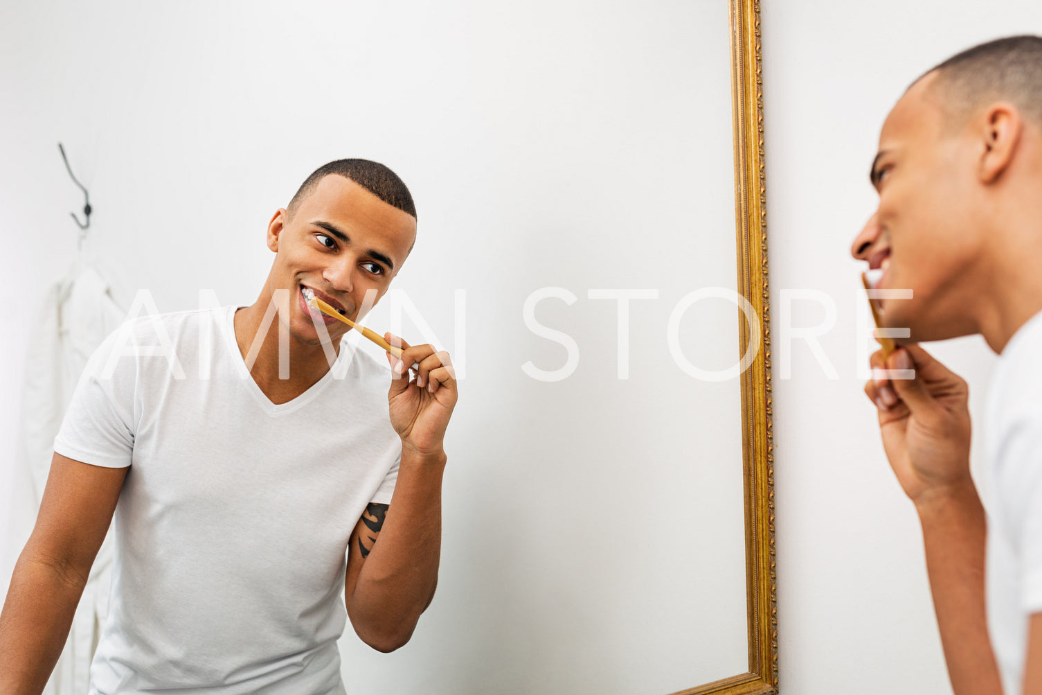 Portrait of a young man brushing his teeth in the bathroom	