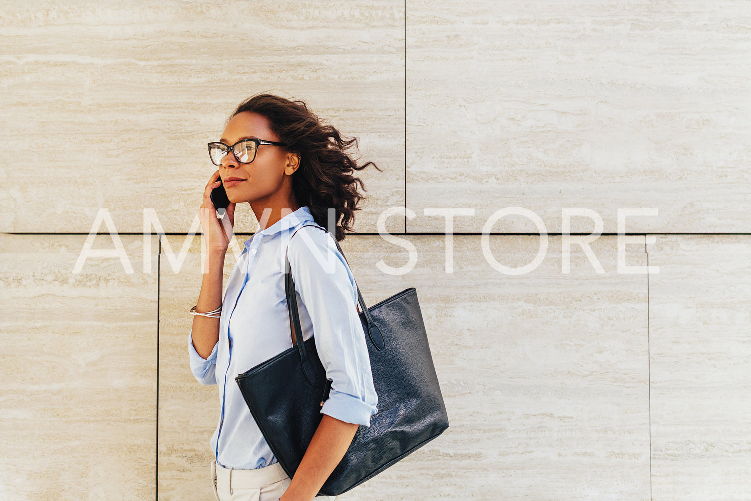 Side view of confident businesswoman walking on city street, carrying bag on shoulder	