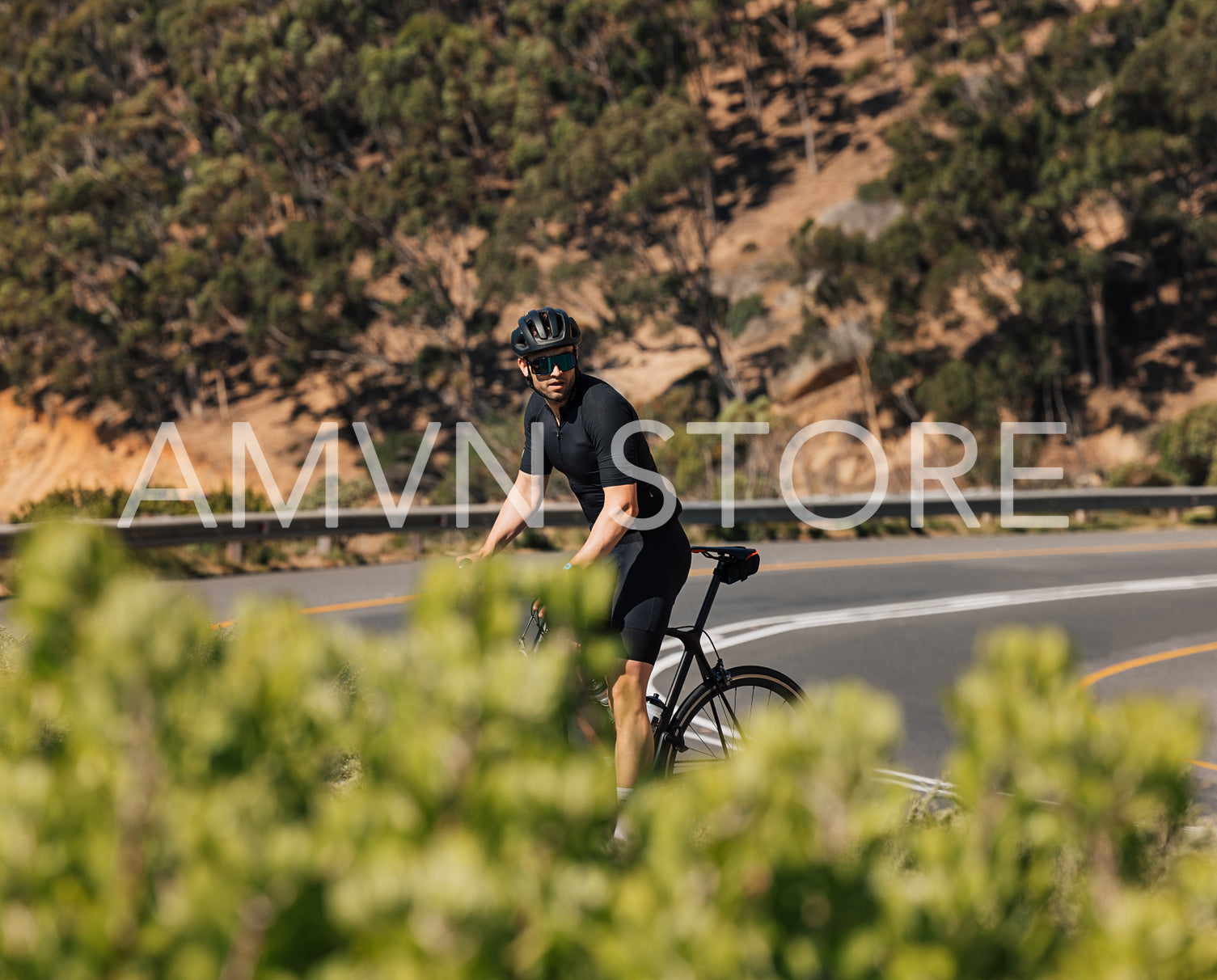 Professional cyclist in black sportswear taking a break on the road during training