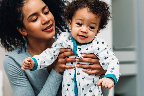 Woman holding her toddler son. Portrait of a young mom with son.