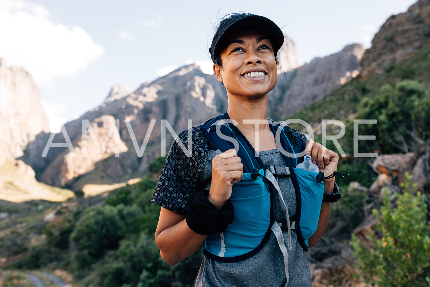 Portrait of positive woman hiker standing in valley. Young female enjoying the hike.