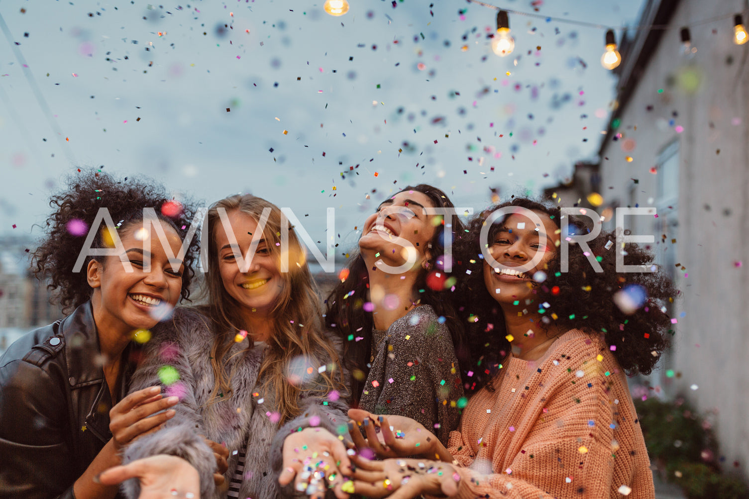 Four beautiful women standing at a terrace under confetti.	