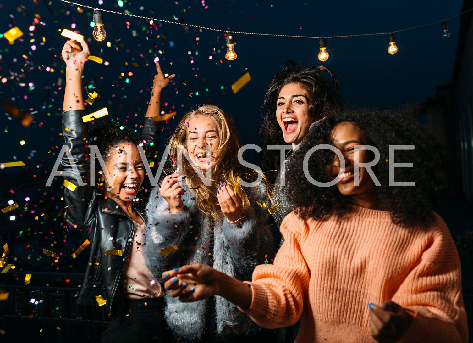 Outdoor shot of group friends laughing under confetti	