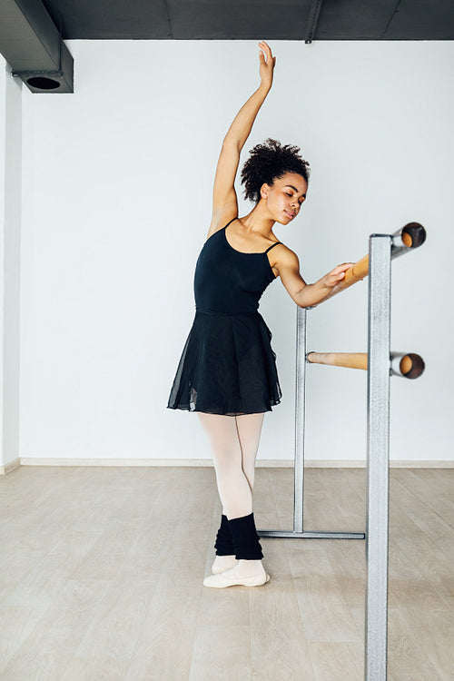 Young artist practicing ballet moves in the studio at barre