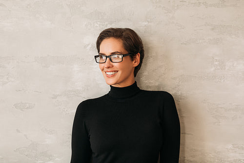 Portrait of a middle-aged businesswoman in eyeglasses smiling and looking away