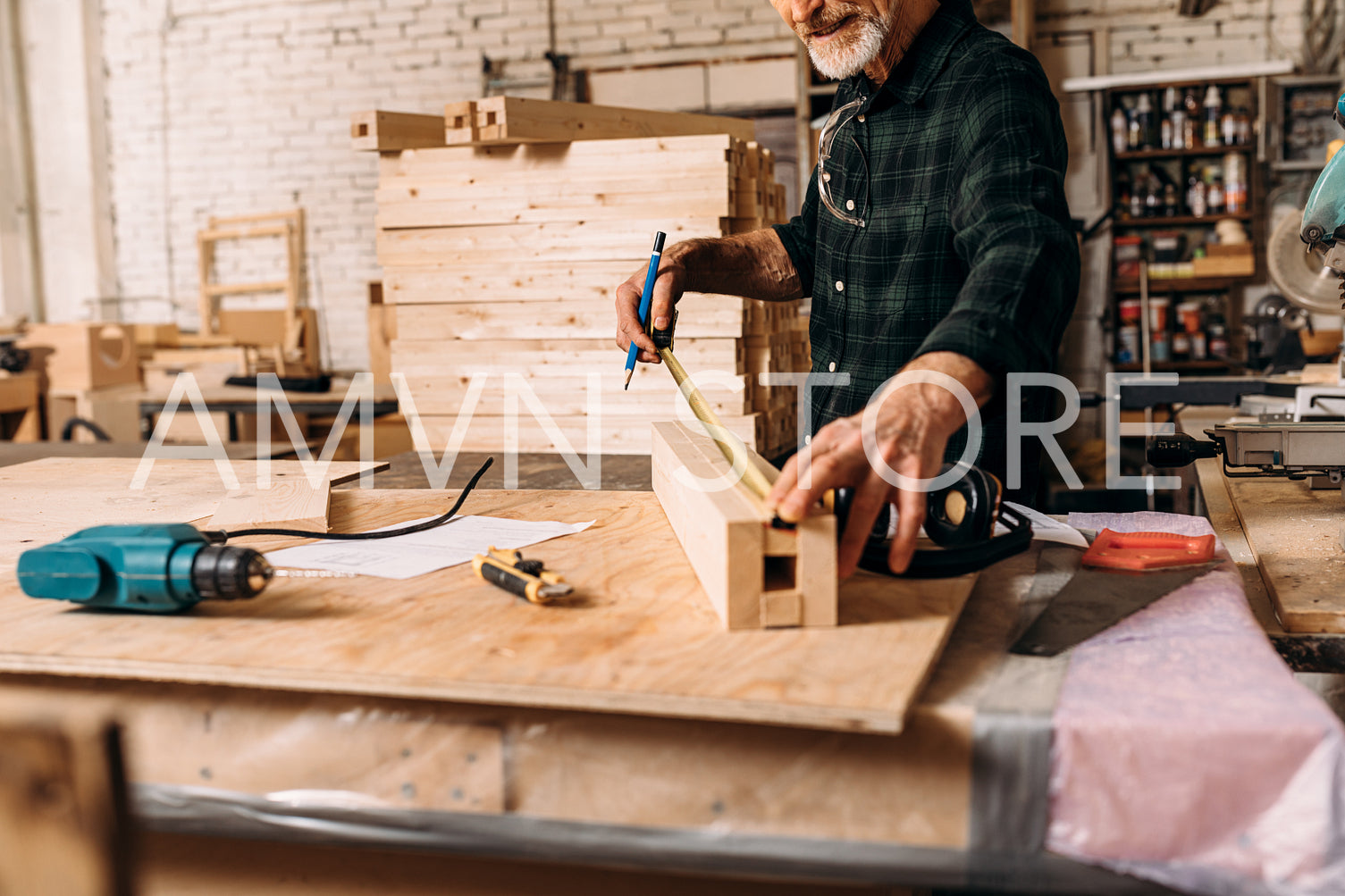 Unrecognizable senior carpenter measuring length of wooden plank in workshop	