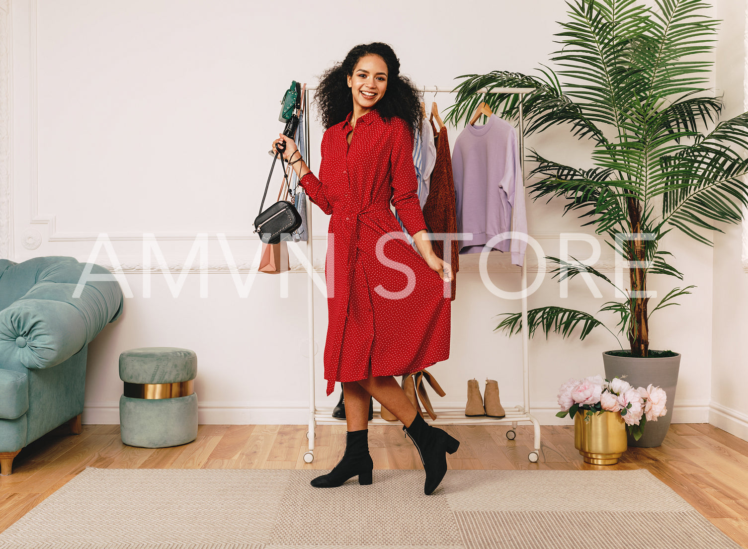 Beautiful smiling woman in studio posing in red dress at clothes rack