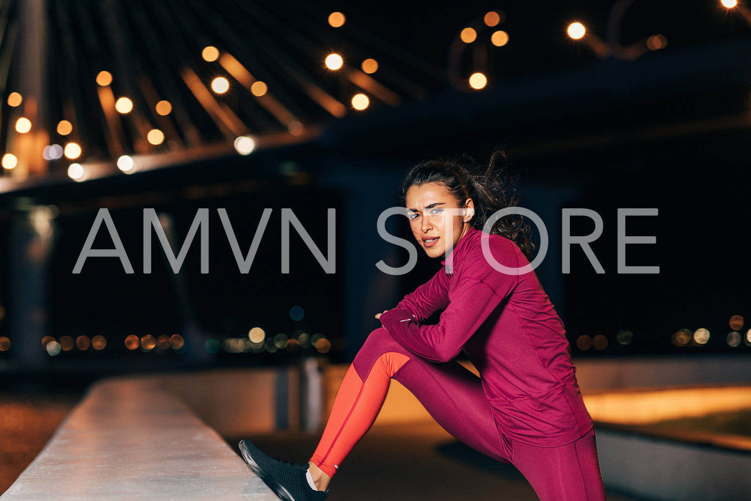 Woman stretching before an evening run. Young female jogger warming up legs at night.