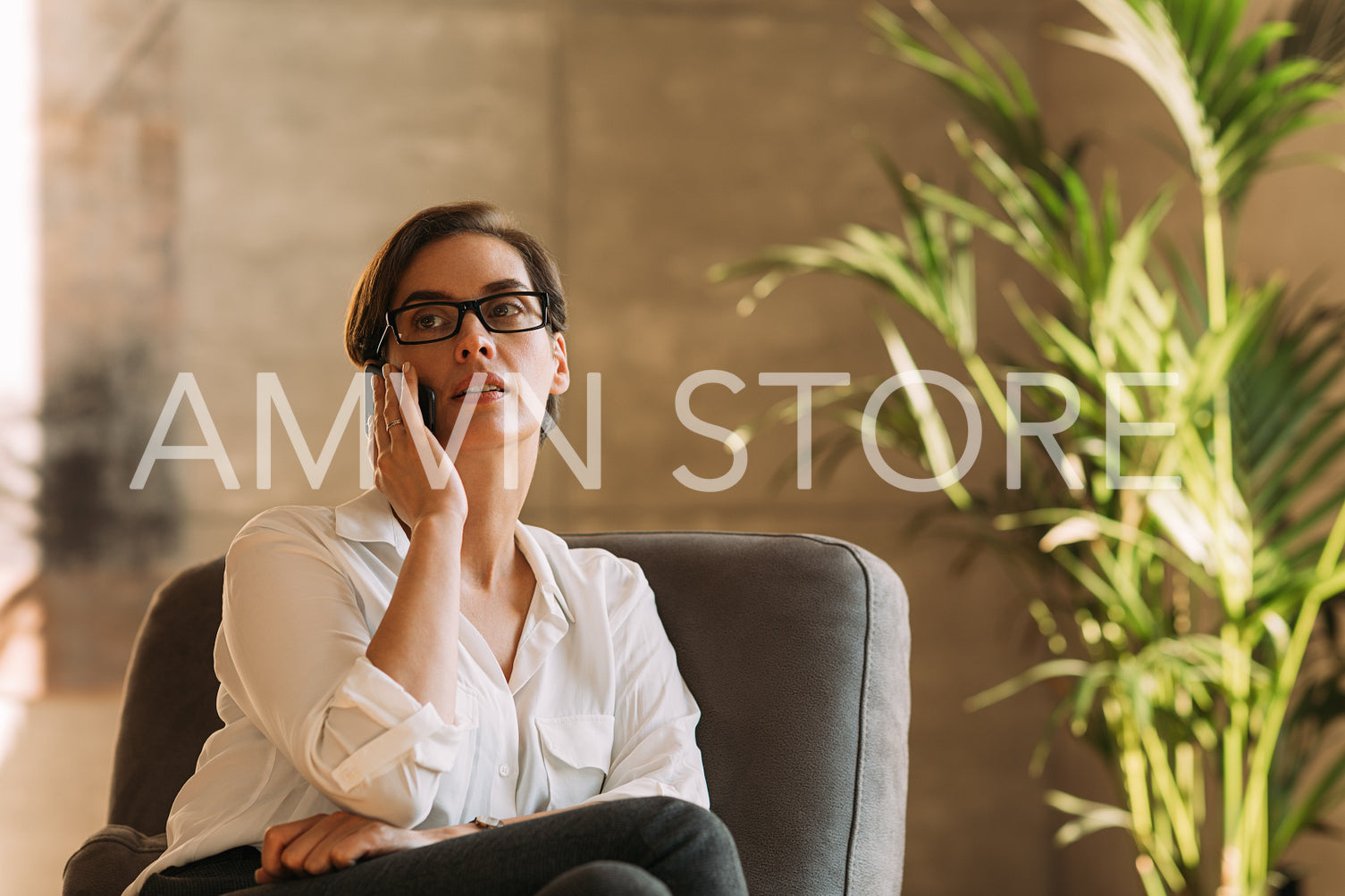 Middle-aged businesswoman in eyeglasses talking on mobile phone  