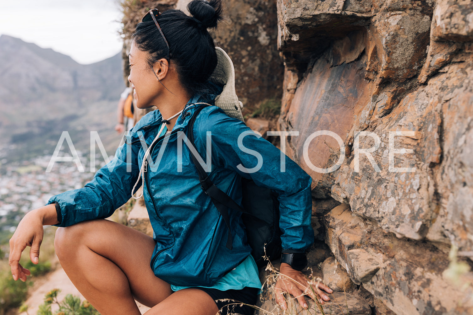 Woman sitting on a mountain looking away. Female hiker looking a