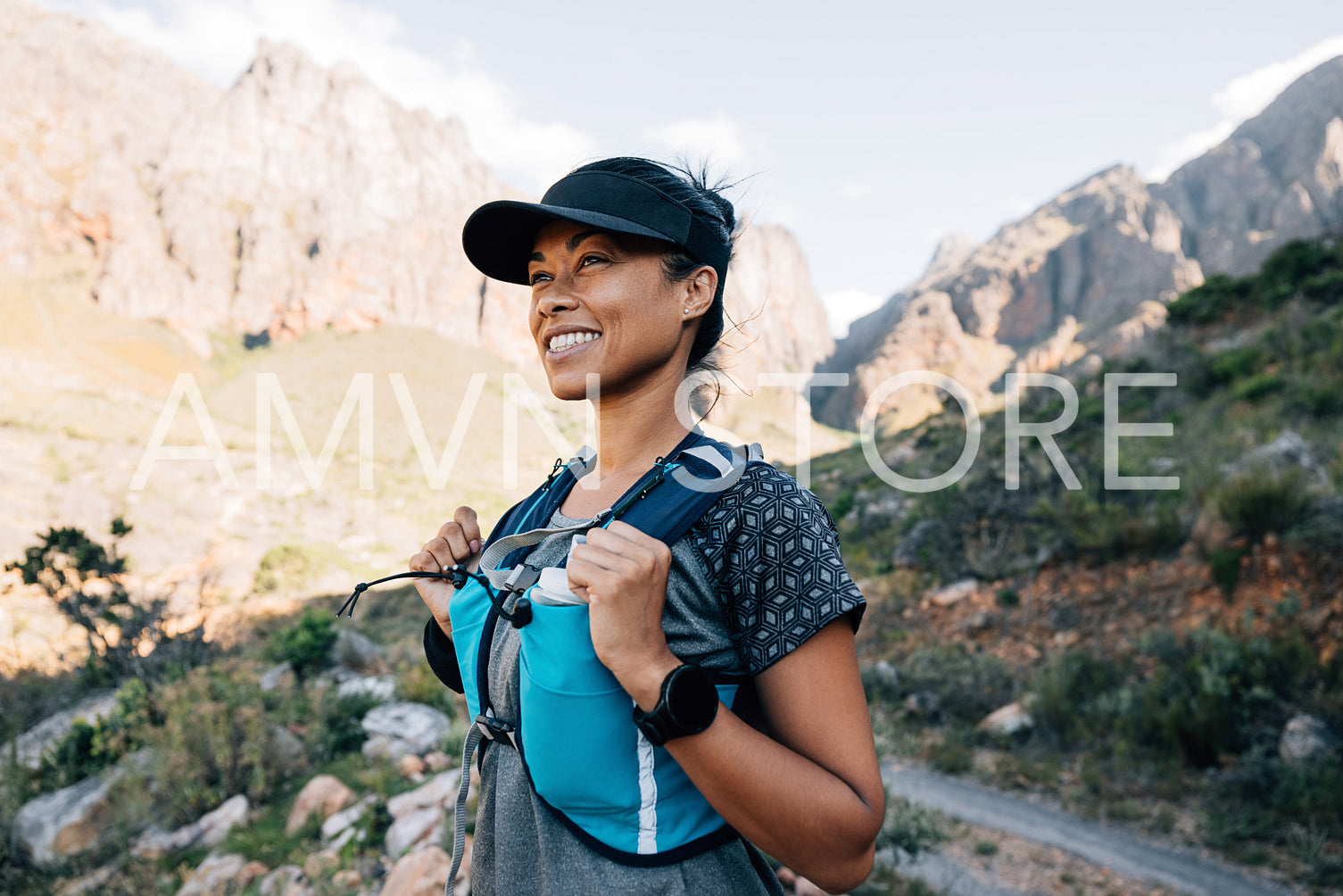 Cheerful woman in hiking attire standing outdoors looking on mountains