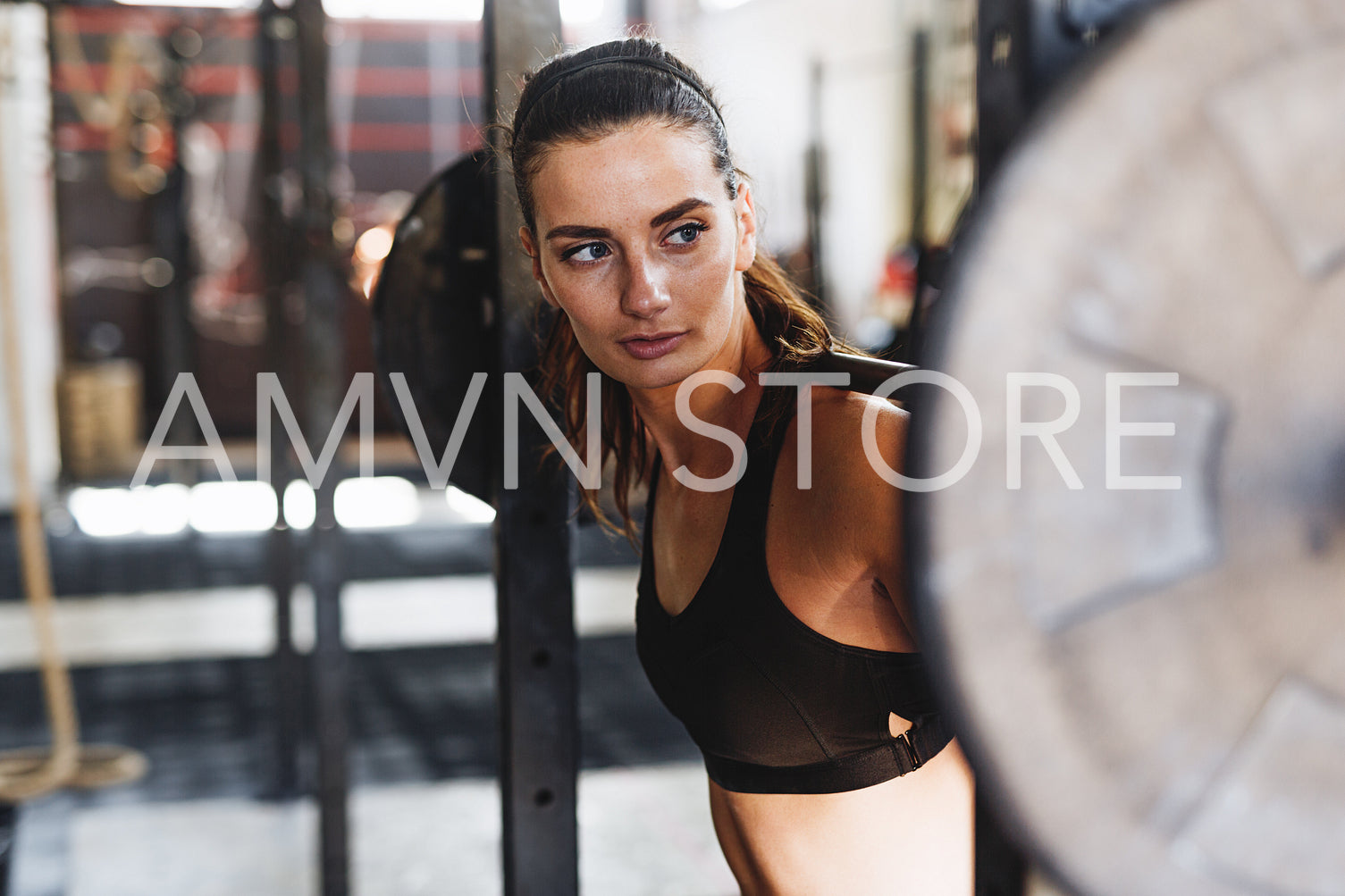 Young sporty woman prepairing barbell for training	