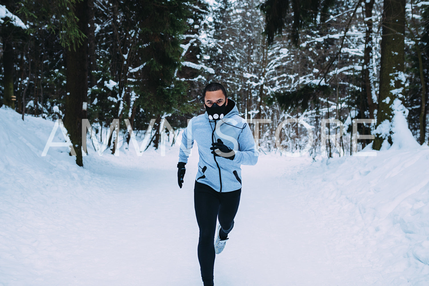 Front view of young sportsman in running mask at forest	