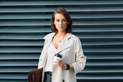 Confident businesswoman with ginger hair. Middle-aged business person wearing stylish clothes holding a leather folder.