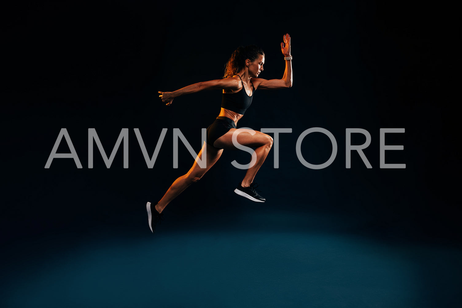 Fit woman running and jumping in the studio. Young female sprinting against dark background.