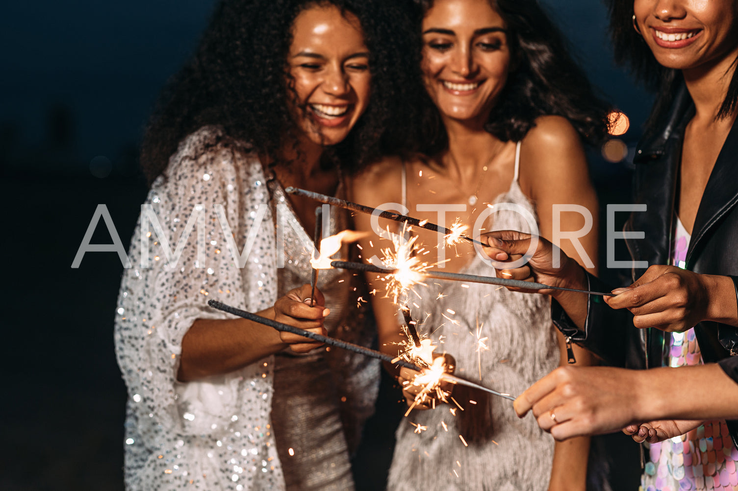 Close up oh happy women holding sparklers at night	